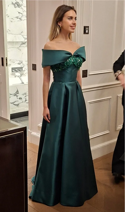 Frau im eleganten, schulterfreien grünen Abendkleid