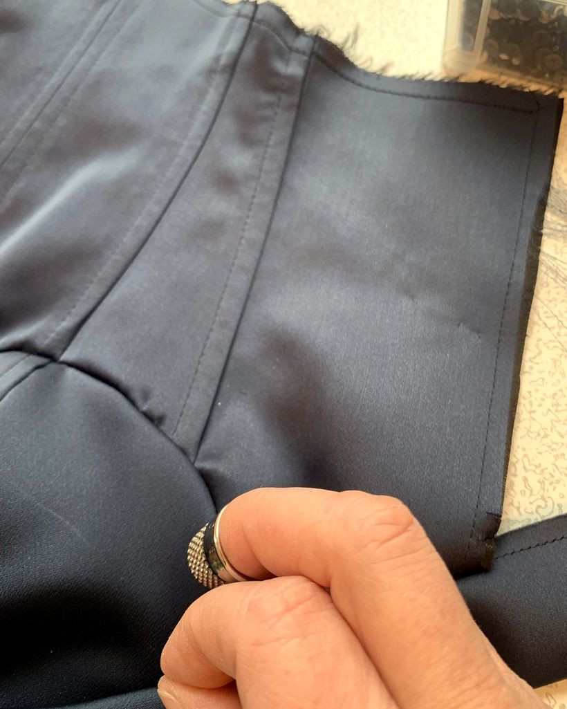 Von Hand geführte Naht auf schwarzem Satin