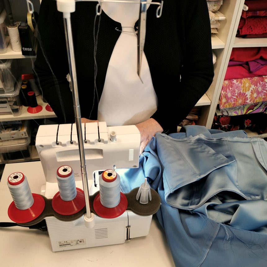 Verarbeitung von blauem Satin an der Overlock