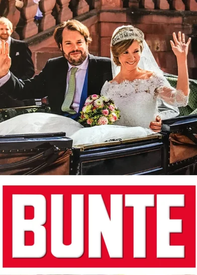 Paar in Hochzeitskleidung winkt von einer Kutsche bei einer Hochzeit